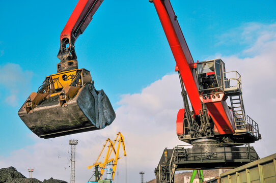 Industrial wagons are unloaded by a hydraulic crane manipulator