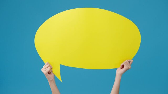 Young teen girl holding with copyspace cartoon speech bubble in hand over blue background. Copy space for place a text, message for advertisement. Advertising area, mockup promotional content.