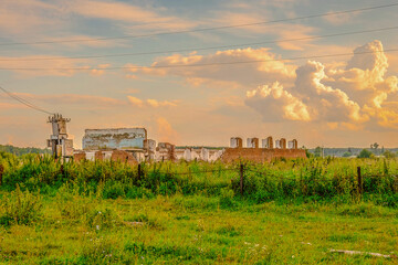 Fototapeta na wymiar Ruined building foundation sunrise scene. Ruins of the castle. On the background beautiful sky with clouds. Old church ruin in a beautiful rural landscape