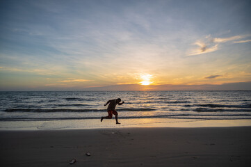Silhouette people jumping with Beautiful idyllic seascape sunset view on kohkood island in low season travel.Koh Kood, also known as Ko Kut, is an island in the Gulf of Thailand