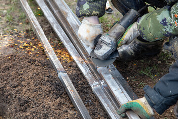 Obraz premium A worker grinds metal at a construction site.