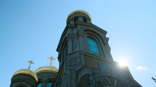 Kubinka, Russia - CIRCA 2021: Close up Orthodox Church or tample in black color with golden domes, sun shine in camera. smooth camera movement, faith in God and Christ. Cathedral in Park Patriot.