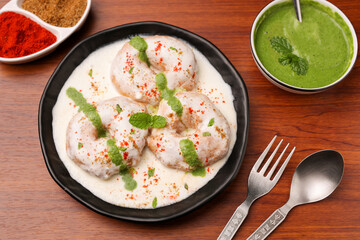 Indian street food thayir vadai Dahi vada Dahi Bhalla with green chutney, tamarind chutney chaat appetizer curd vada soaked in yogurt. South Indian snack Tamil Nadu Kerala Andhra India, sri Lanka.