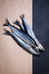 four river fish marinate in spices against the background.