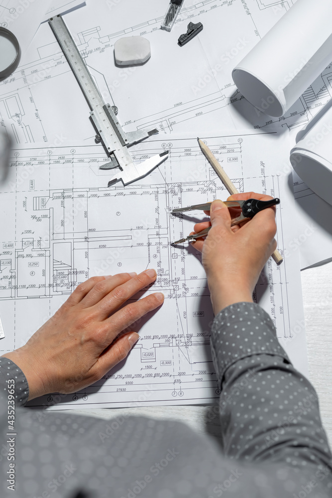 Poster the hands of a professional architect draw a sketch of a design project with a pencil. work table of