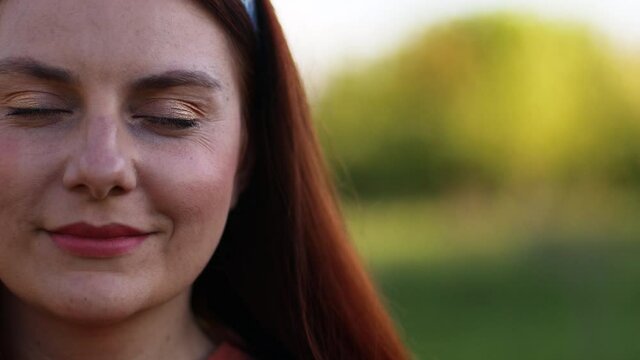 Beautiful young caucasian girl with red hair flying in the wind looking at the camera. People freedom style.