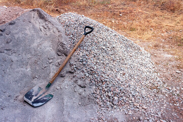 The shovel is lying on a pile of sand and gravel. Concept - building materials, repairs,...