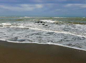 le onde che si infrangono sul bagnasciuga della spiaggia invernale