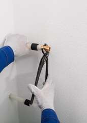 plumber's hands lead water into the room using sewn polyethylene pipes