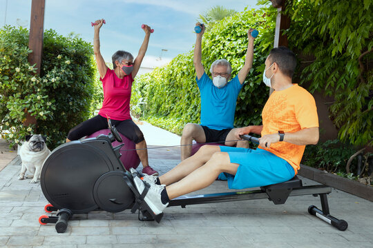 
Senior couple exercising at home with personal trainer. Exercise at home during the pandemic. Training at home as a family. Lifestyle photography