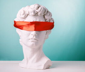 Plaster head with eyes covered red satin ribbon on blue background. Avoid problems concept. - obrazy, fototapety, plakaty