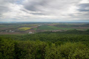 Fototapeta premium View of the landscape above the spring forest and with cloudy skies 