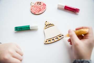 wooden Christmas tree for coloring, paint and gift box on white background. art project. DIY concept.The idea of creating Christmas gift with your own hands.Little child is decorating wooden toys