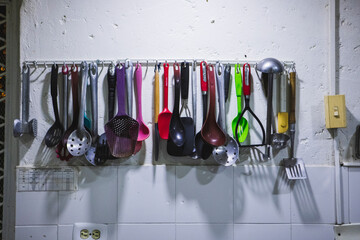 Closeup shot of spoons hanging from a wall in a kitchen