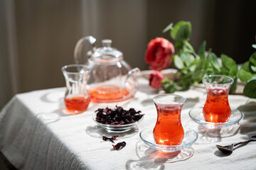 Hot red karkade tea in a glasses on rustic background