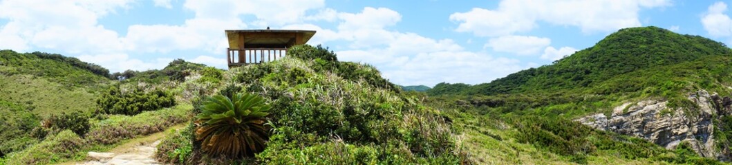 Fototapeta na wymiar Beautiful mountain path and cottage at Chishi observation deck in Zamami island, Okinawa, Japan. Panoramic view - 日本 沖縄 座間味島 チシ展望台からの眺望