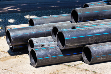 Plastic main pipes. A heap of polyethylene pipes for a water supply system. Objects for laying of...