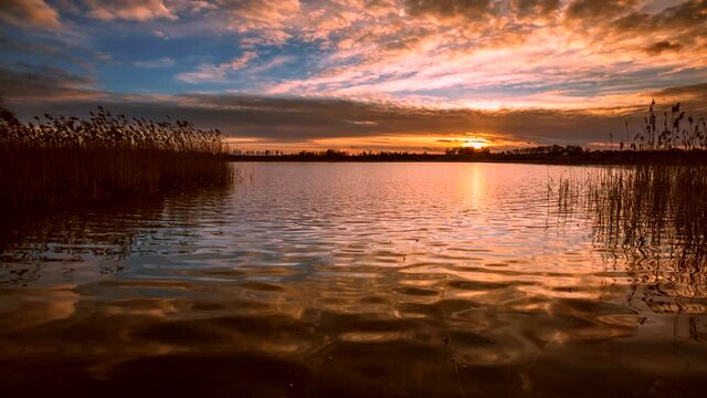 Lake landscape with beautiful golden sunset. Time lapse video.