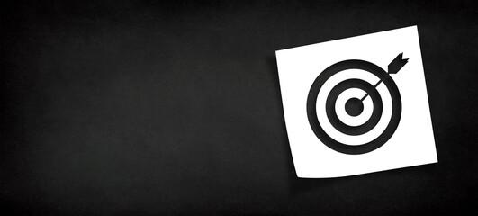 Note paper and target sign with copy space on panoramic black background