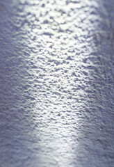 Shadows and light on a rough gray surface.