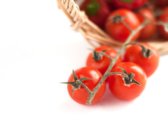 Cherry tomatoes in a basket on the white background.