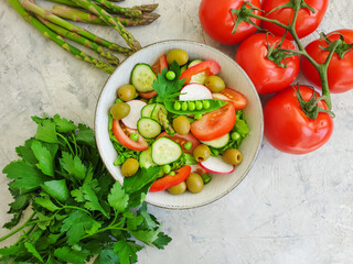 Fototapeta na wymiar fresh vegetable salad, olives on a concrete background