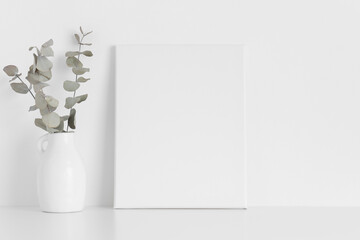 White canvas mockup with an eucalyptus on the table.