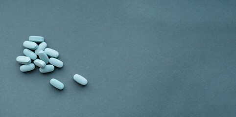 group of blue pills on a blue background. place for text. top view