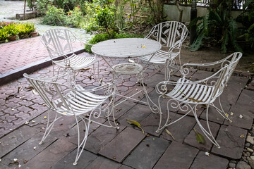 White round table with chairs in a backyard