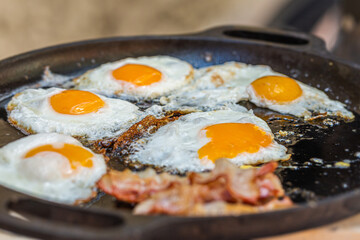 Bacon and fried egg on the grill. Close up