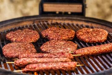 Prepared meat cutlet for burger on grill, closeup