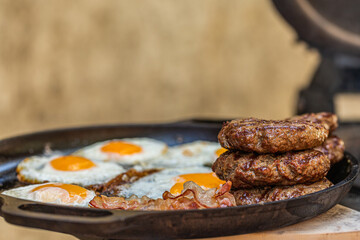 Prepared meat cutlet and fried egg for burger on pan, closeup