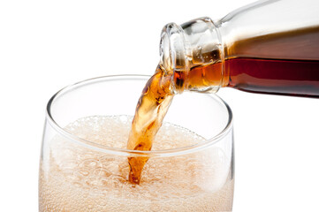 Carbonated drink poured out of bottle into a glass isolated on a white background