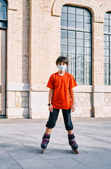 Caucasian boy with mask playing with roller skates in the park.