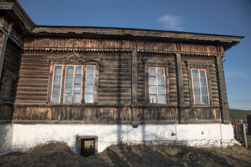 An old wooden house with beautiful windows. Blue sky. Country house.