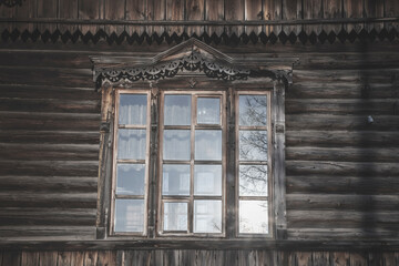 Fototapeta na wymiar Antique beautiful window in a wooden house. Country house. Reflection of the sun in the window.