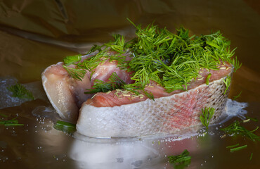 Salmon steak with dill and herbs on metalpaper, closeup, horizontal