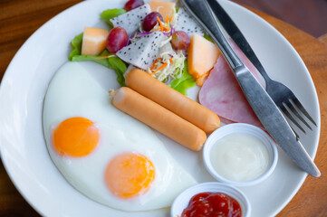 American Breakfast with sausages Fried Eggs and Fruit and Vegetable Salad.