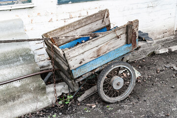 Old wheelbarrow. Old worn wheelbarrow for wood stands in a farm.