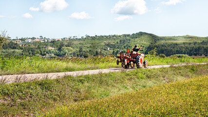 Farmer on tractor waving with his hands