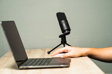 hand action with a microphone and laptop podcast