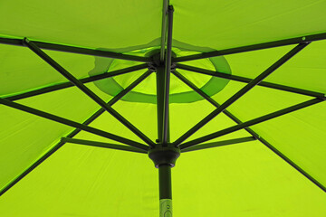 Canopy of an open yellowish green sunshade umbrella in close-up full frame view