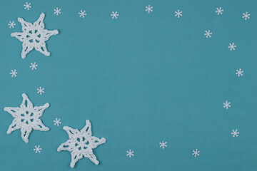 Blue Christmas background with crocheted snowflakes.