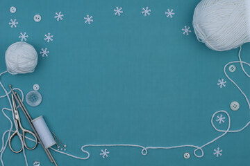 Blue Christmas background with snowflakes, scissors, needles, buttons, and white threads.