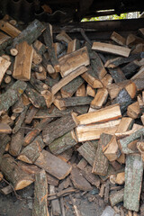 A pile of firewood. Lots of wood logs. The logs are stacked in a wood shed. Protection of ecology.