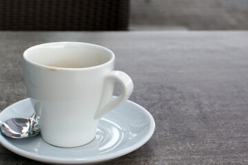 white porcelain coffee cup on table with saucer and spoon