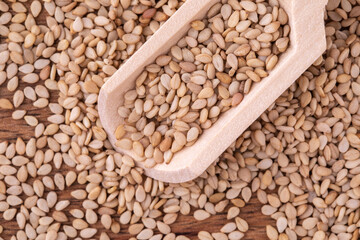 Sesame seeds on wooden background, close up