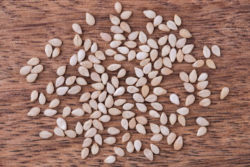 Sesame seeds on wooden background, close up