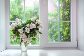 Bouquet of white lilac in a vase on the windowsill - obrazy, fototapety, plakaty