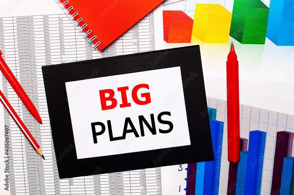 Poster reports and color charts are on the table. there are also red pens, pencil and paper in a black fram